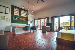 Quarto espaçoso com cozinha, mesa de jantar e uma grande janela com vista.