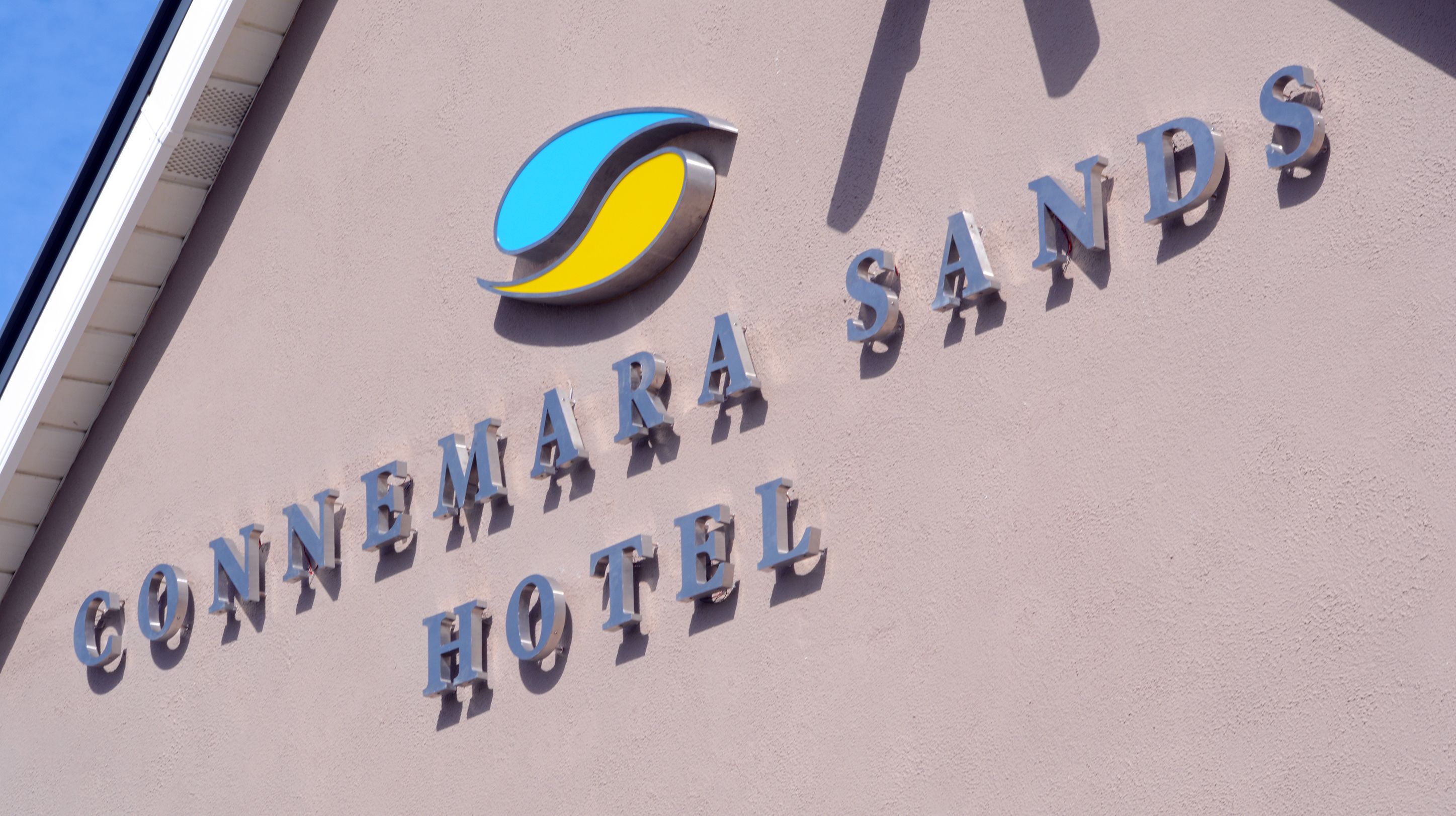 The exterior of the Connemara Sands Hotel with a logo and the name of the hotel.