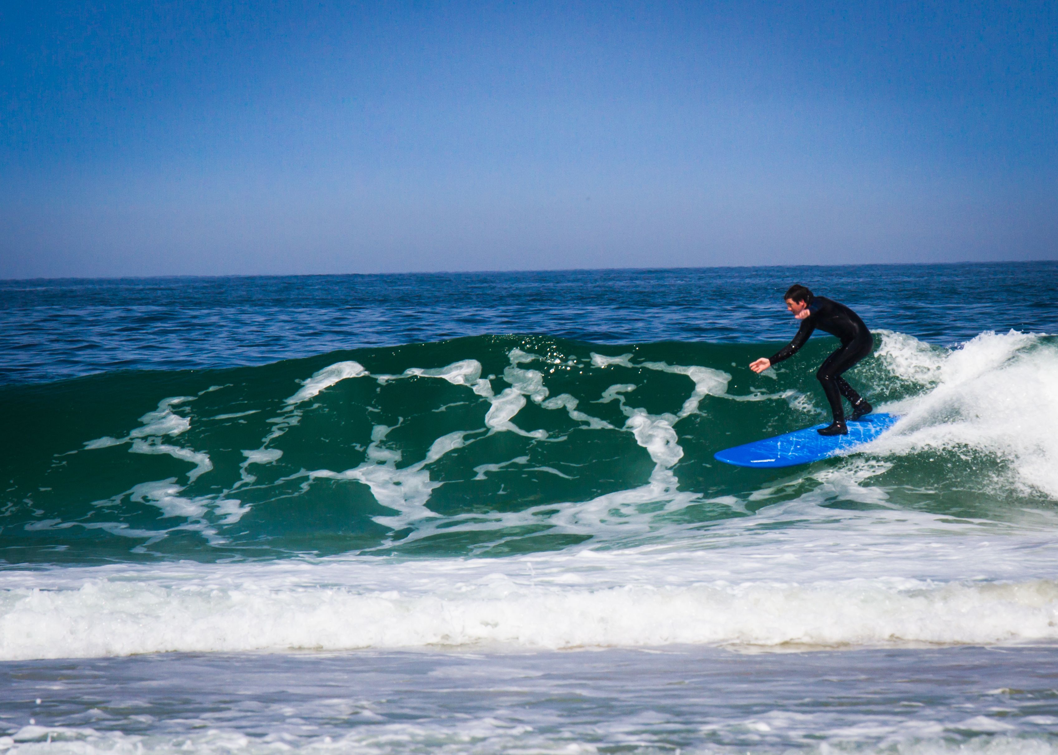 A person surfing on a wave in the ocean.