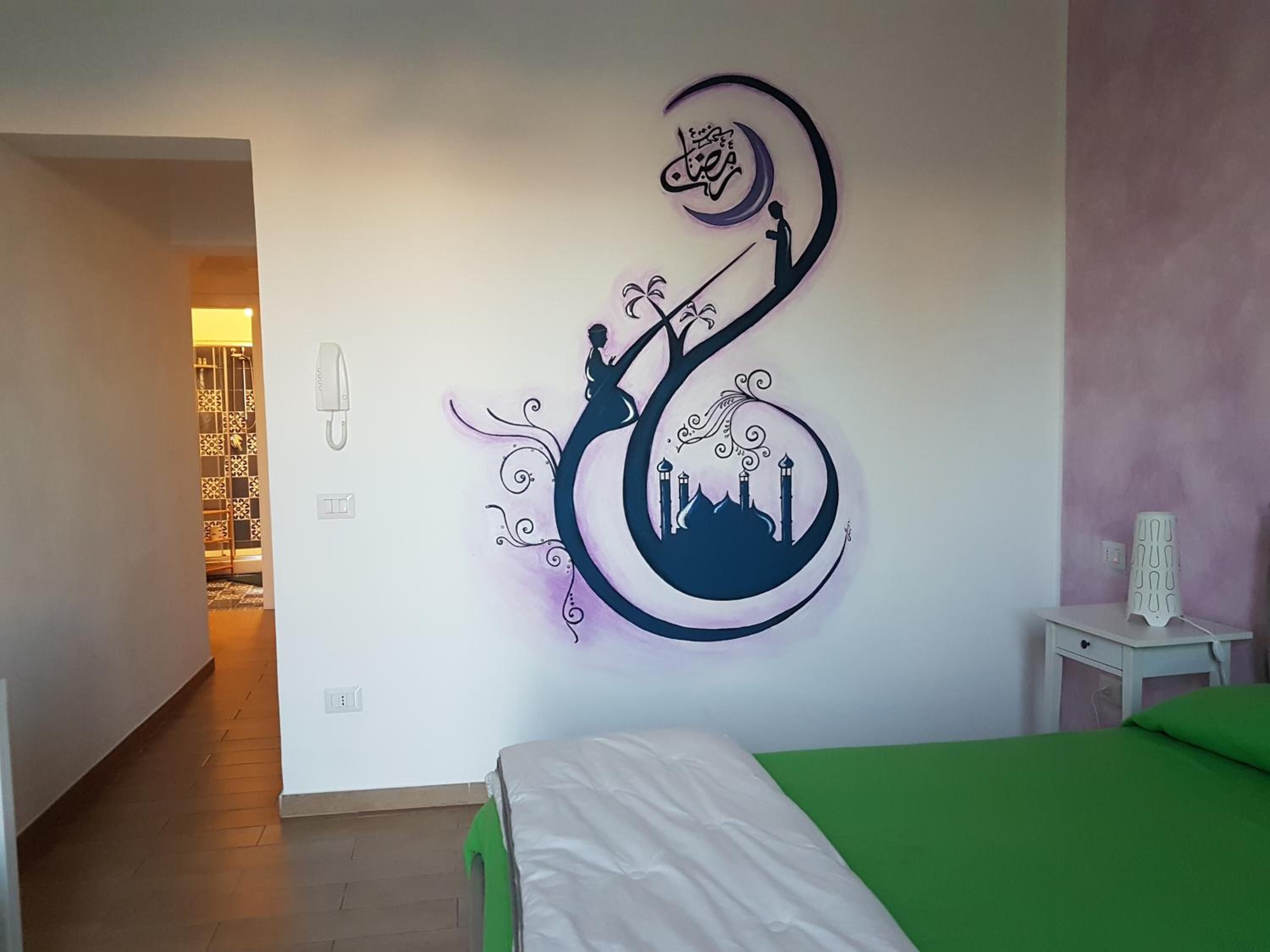 Ein Schlafzimmer mit Bett, Nachttisch und einer Wand mit dekorativem Design.