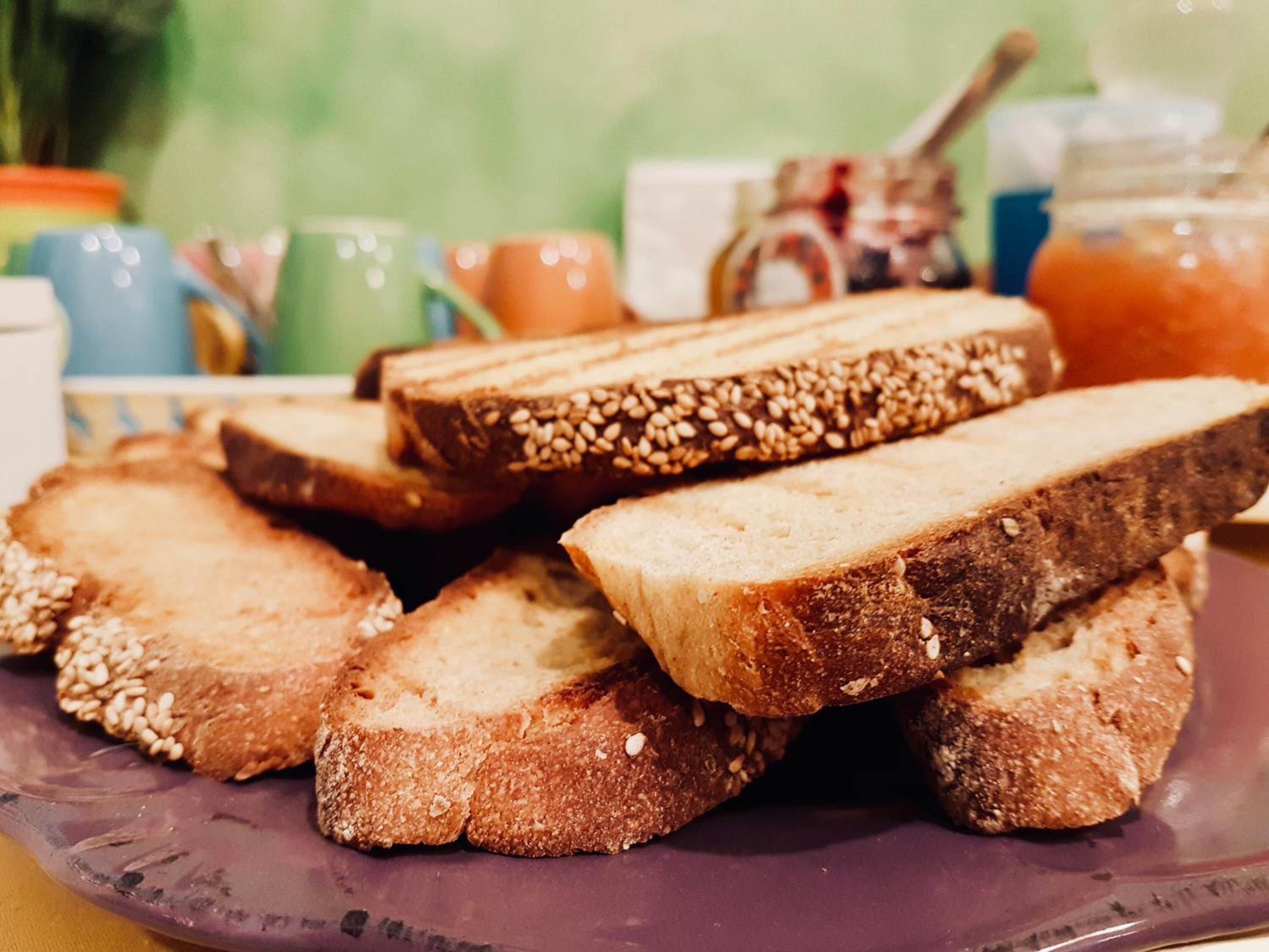 A stack of sliced bread with sesame seeds on a purple plate.