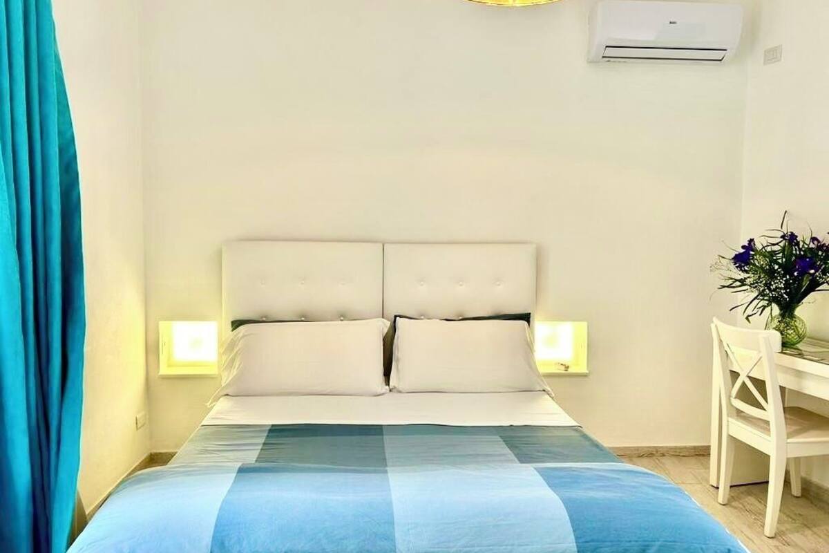 Ein Schlafzimmer mit Bett, Nachttischlampen, Schreibtisch und Stuhl.