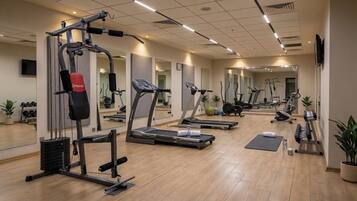 A gym with treadmills, weight machines, and exercise balls.