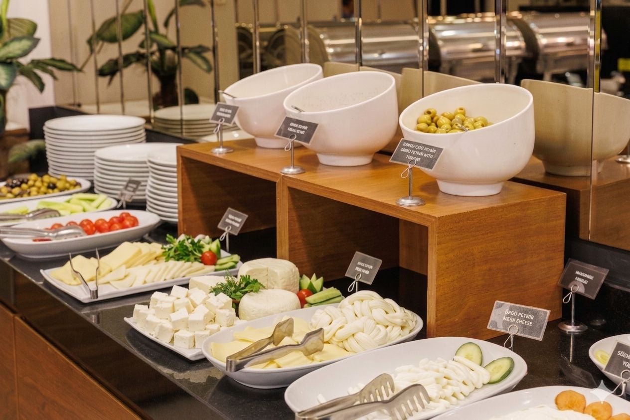 Ein reichhaltiges Buffet mit Käse, Oliven und Gemüse.