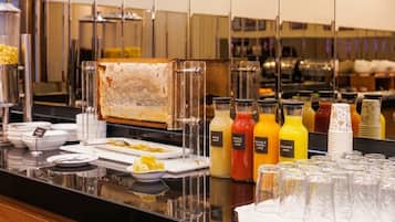 Disposición de bufé con diversos alimentos y bebidas.