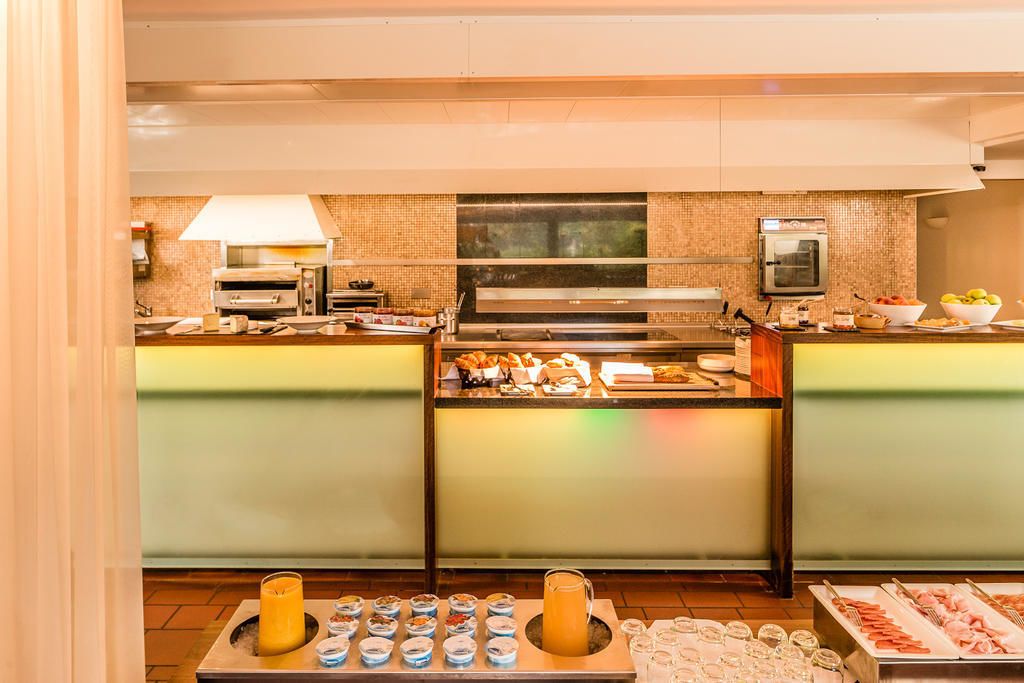 Montaje de bufé con diversos alimentos, una estación de café y un microondas.