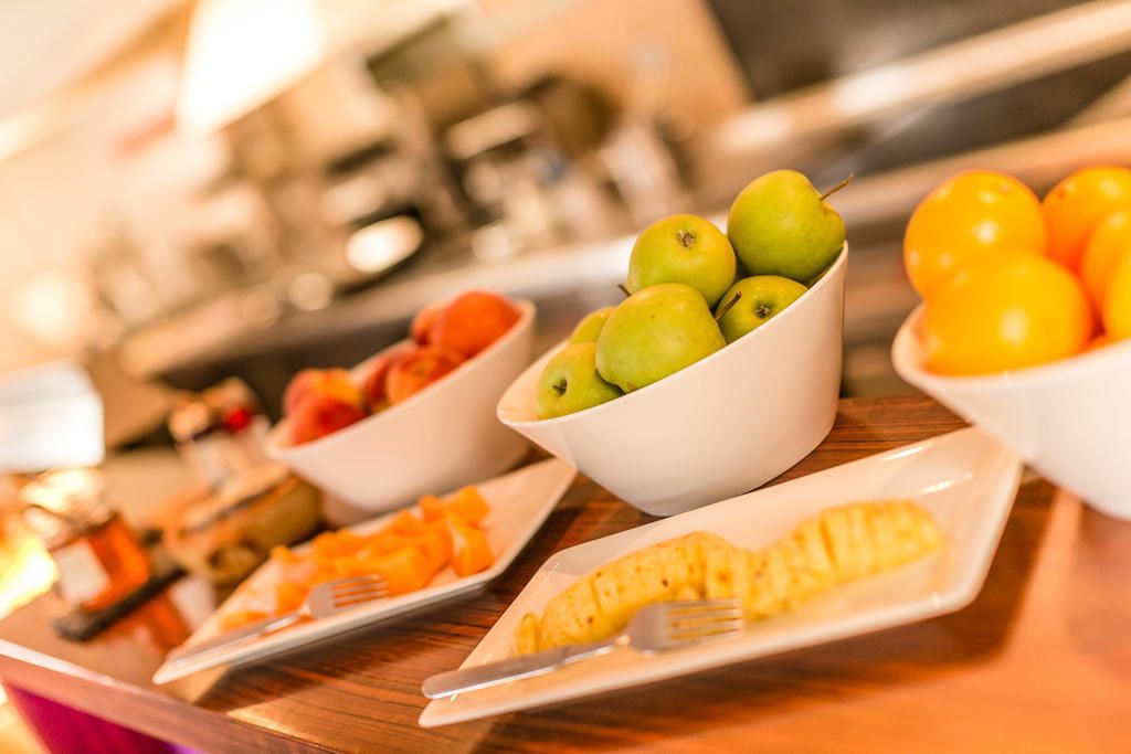 A breakfast buffet with various fruits and pastries.