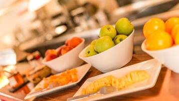 A breakfast buffet with various fruits and pastries.