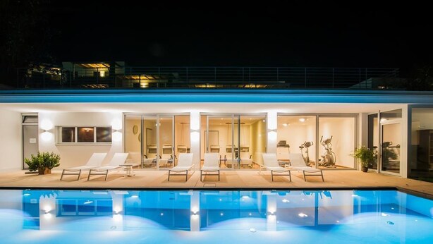 A modern hotel with a swimming pool, sun loungers, and glass doors leading to the rooms. - Hidalgo Suites & Restaurant (Postal)