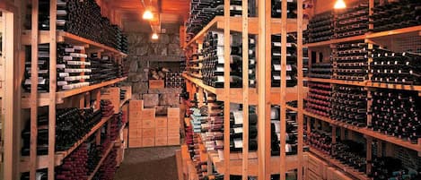A wine cellar with wooden racks filled with wine bottles.