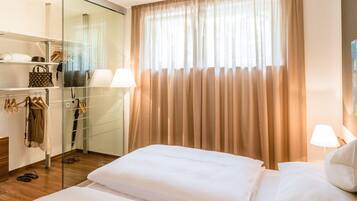 Ein Hotelzimmer mit Bett, Glastisch und einem Vorhangfenster.