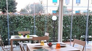 Un patio al aire libre con una mesa para dos, rodeado de sillas.