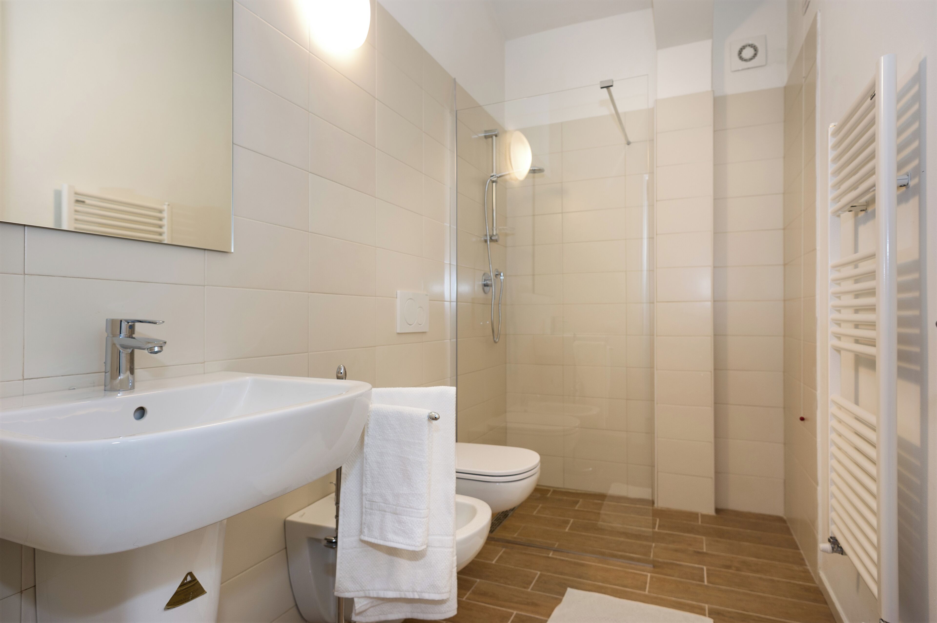 Une salle de bain moderne équipée d’un lavabo, de toilettes et d’une douche.