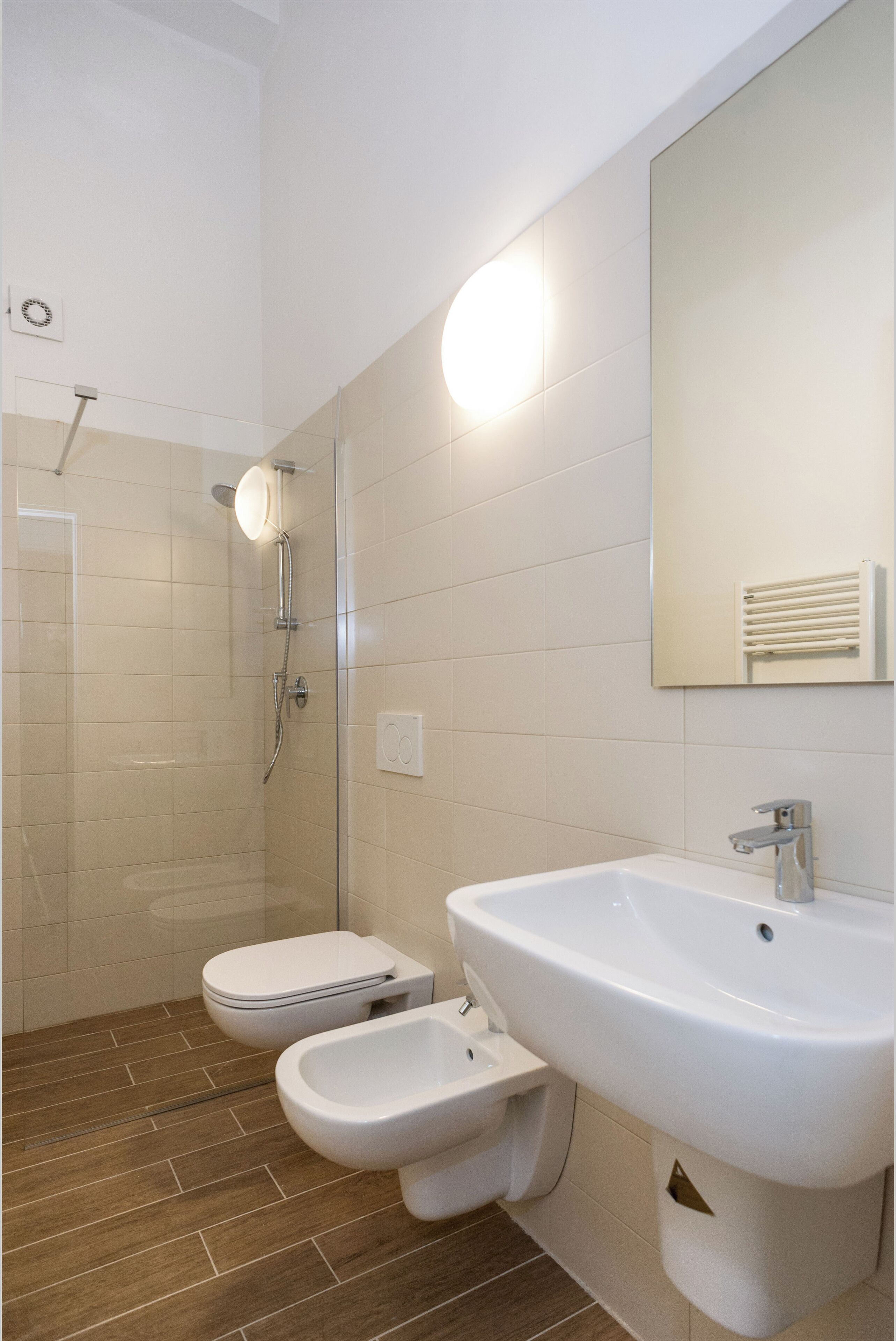 Ein modernes Badezimmer mit Dusche, Toilette, Bidet und Waschbecken.