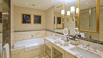A modern bathroom with a double sink vanity, a large mirror, and a bathtub.