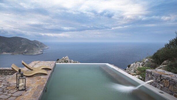 Una piscina a sfioro con vista sul mare e sulle montagne.