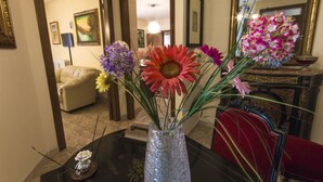 Un comedor con una mesa, sillas y un florero con flores.