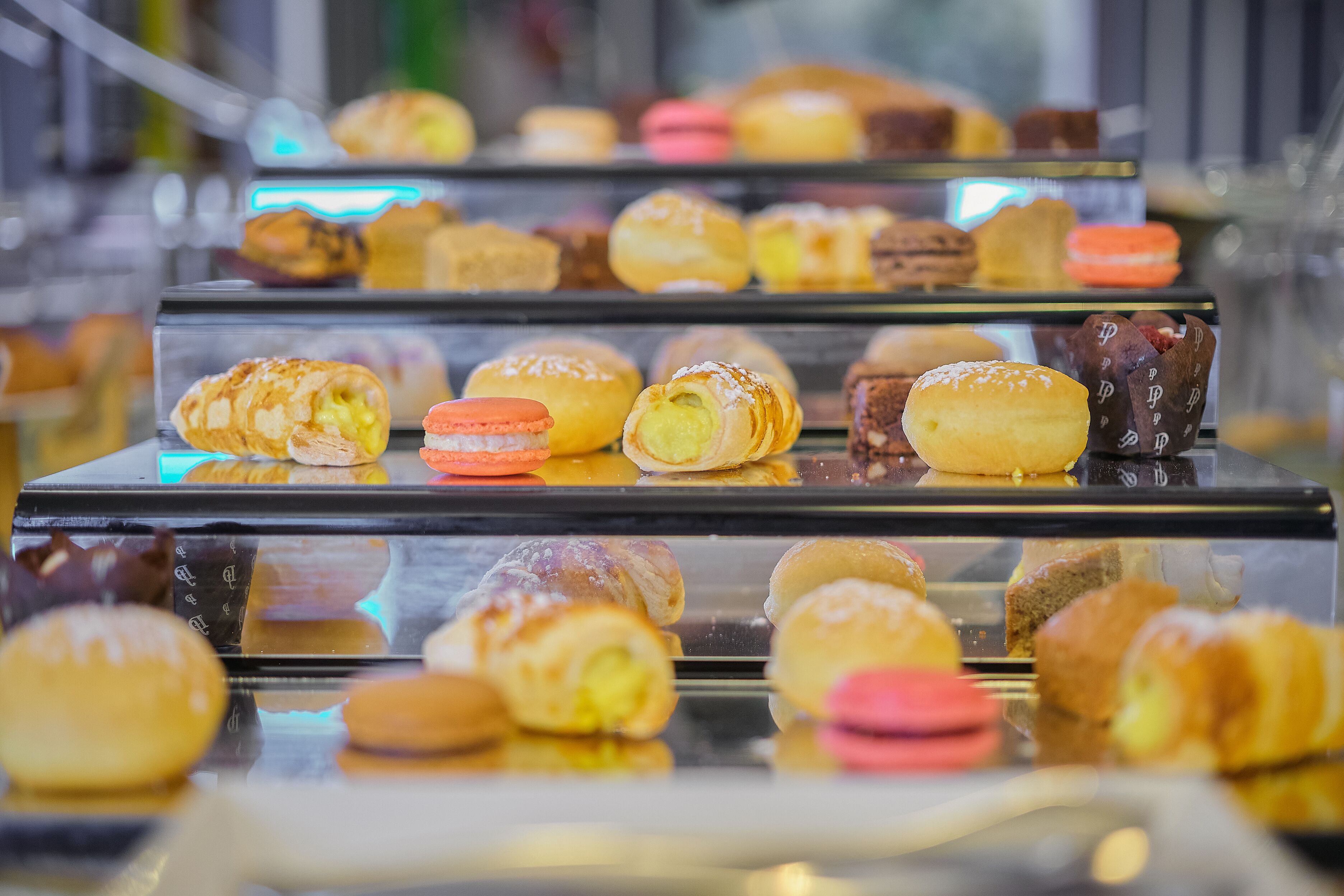 A display case with various pastries and baked goods.