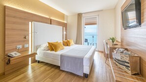 Une chambre d’hôtel moderne dotée d’un grand lit, d’un bureau, d’une télévision et d’un balcon avec vue.