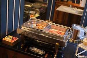 Un bufé con diferentes opciones de comida y una caja de madera con condimentos.