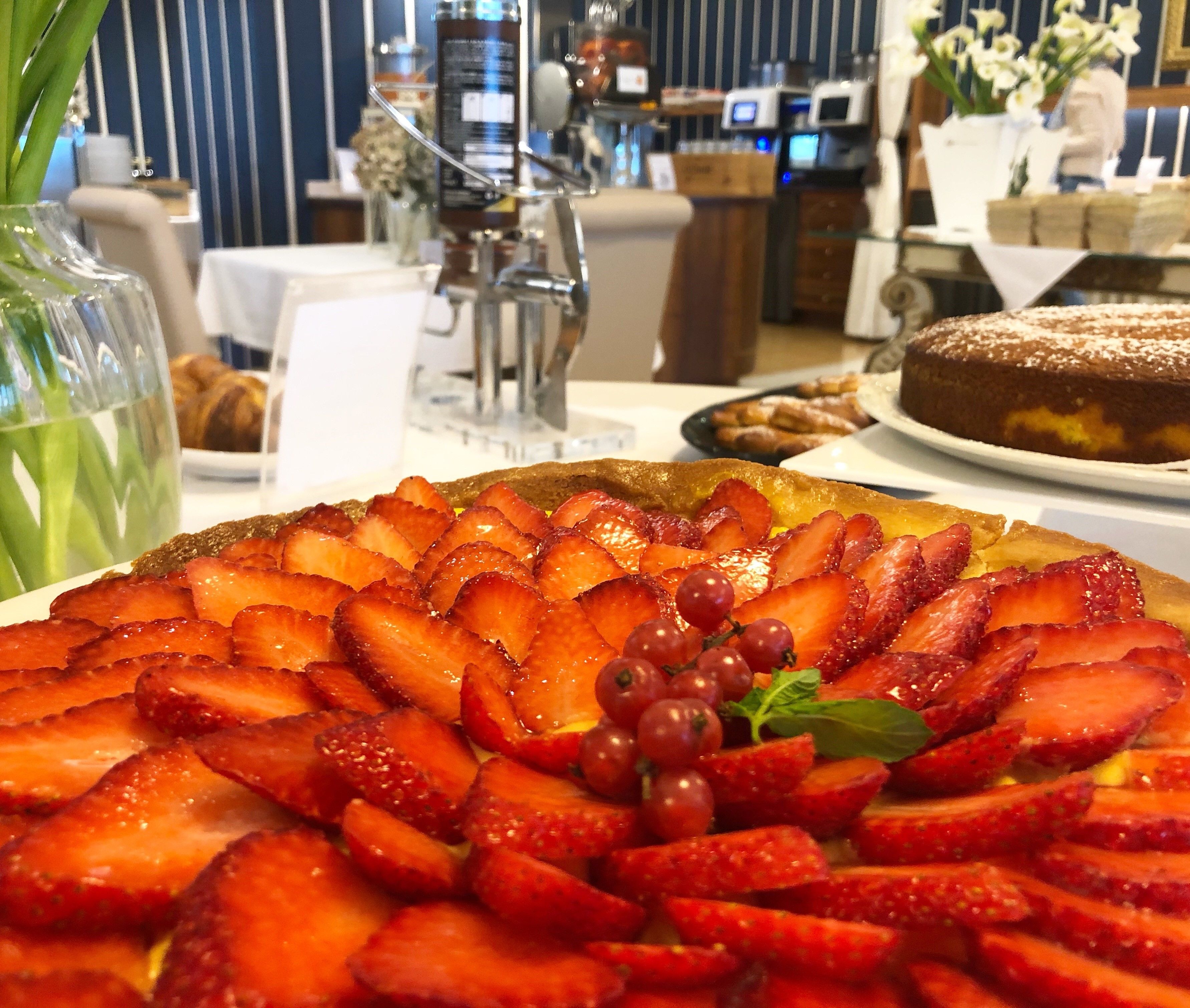 Un plato de postres con fresas y uvas sobre una mesa en un restaurante.