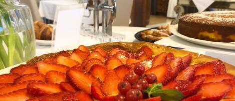 Un plato de postres con fresas y uvas sobre una mesa en un restaurante.