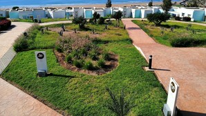 A coastal hotel with a beach view, a landscaped garden, and a clear sky. - Lunja Village Taghazout (Tamri)