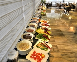 Una barra de buffet con diversos platos y utensilios.