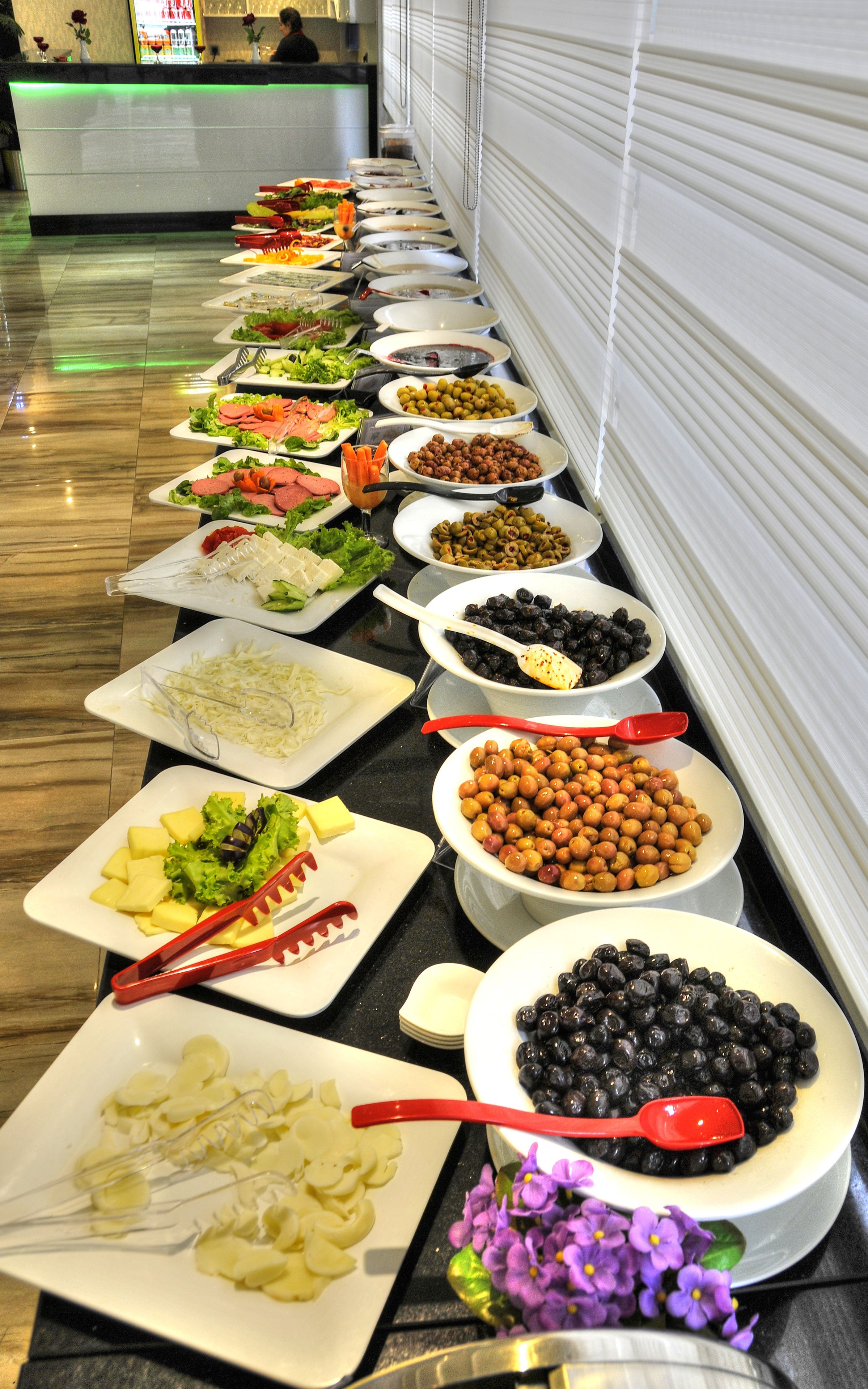 Una mesa de buffet con diversos alimentos y utensilios.