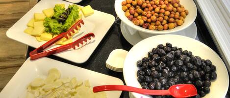 Una mesa de buffet con diversos alimentos y utensilios.