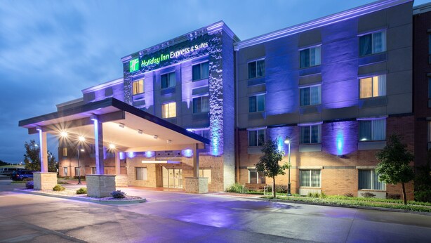 A Holiday Inn Express & Suites building with a covered entrance and a brick facade. - Holiday Inn Express & Suites Manhattan by IHG (Manhattan)