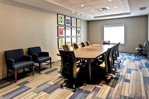 A conference room with a large table, chairs, and framed artwork on the wall. - Holiday Inn Express & Suites Manhattan by IHG (Manhattan)