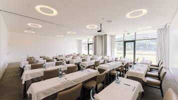 A conference room with tables, chairs, and water bottles.