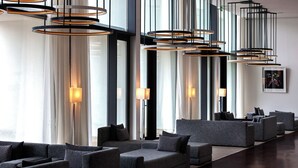 A modern hotel lobby with multiple seating areas, large windows, and contemporary lighting fixtures. - Douro Royal Valley Hotel & SPA (Baiao)