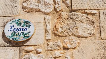A stone wall with a round sign that reads "Lagara."