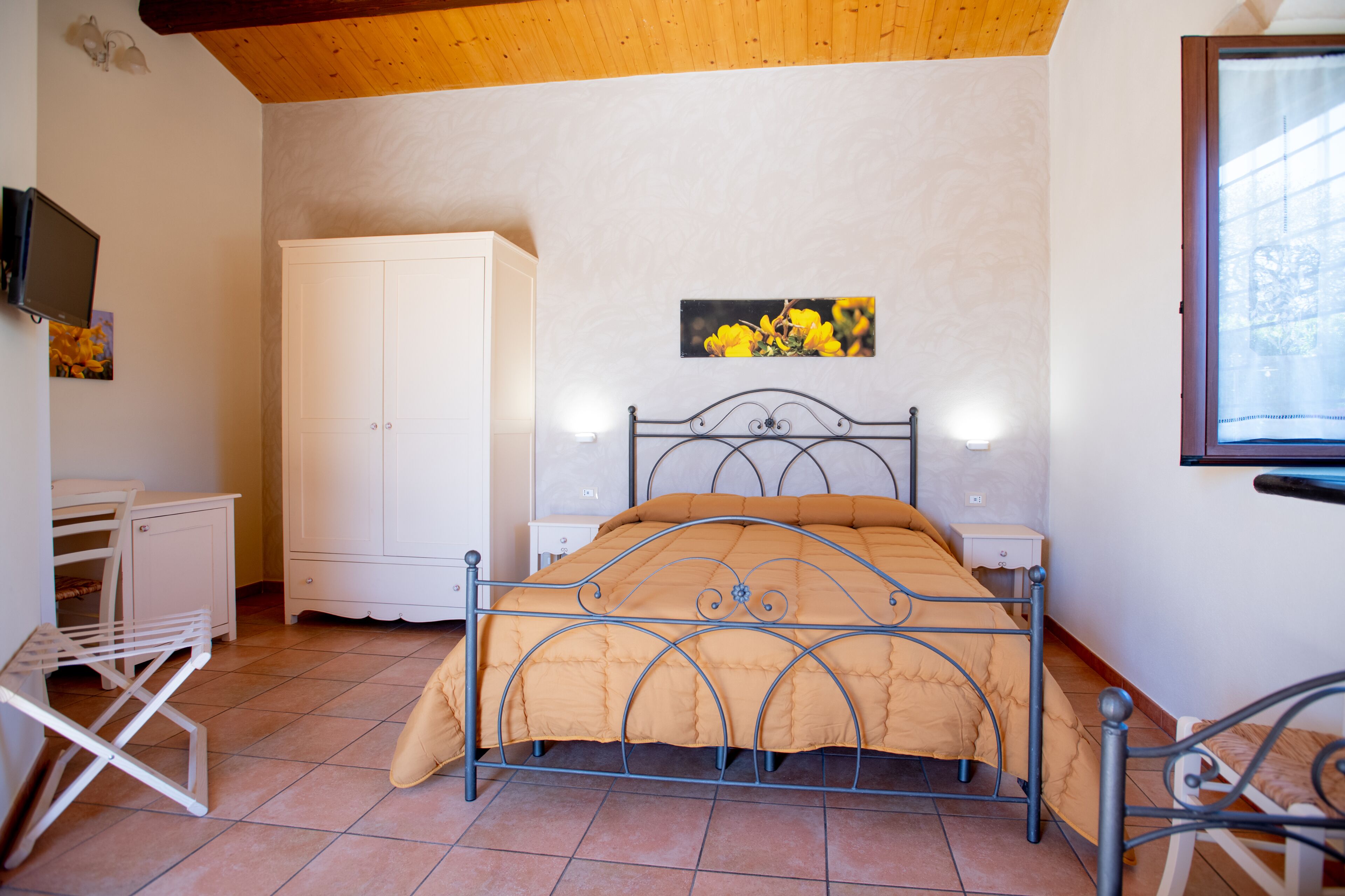 A bedroom with a bed, a wardrobe, a desk, and a chair.