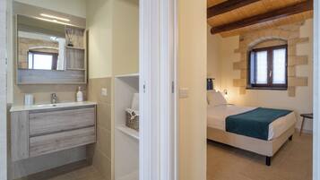 A bedroom with a bed, bedside table, and a window.