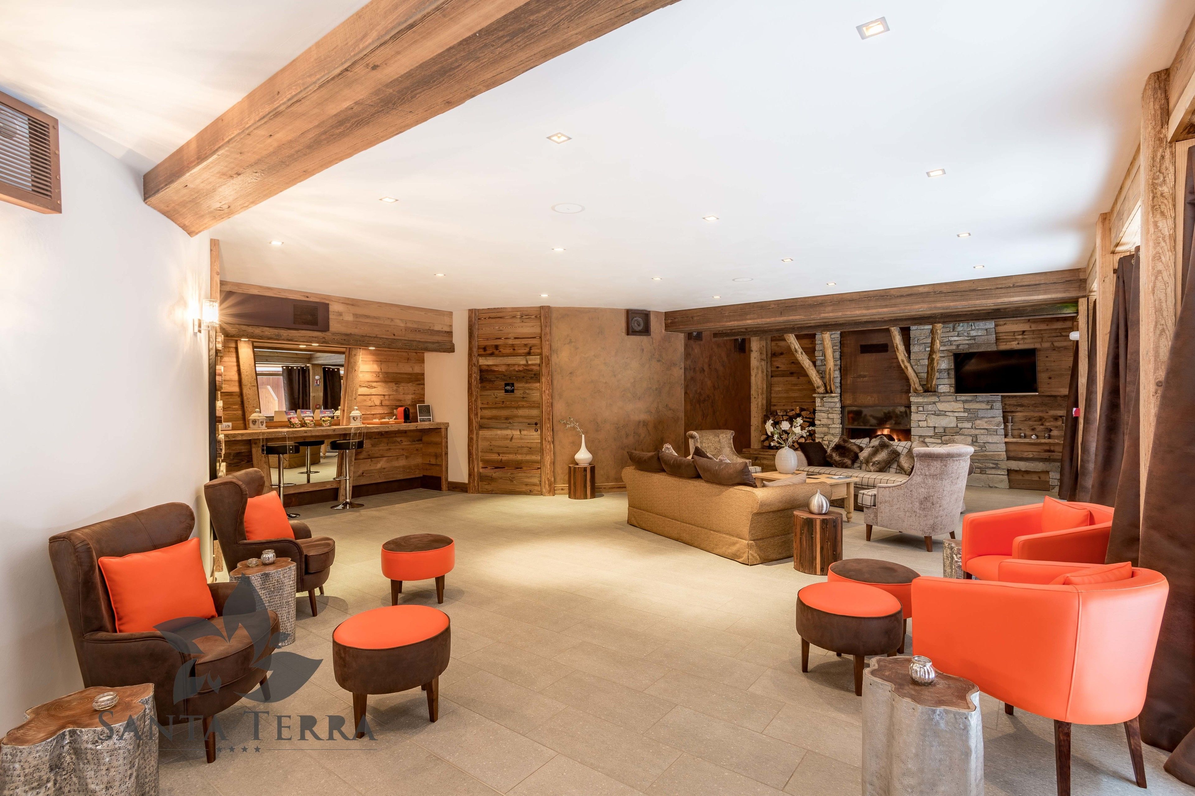 A spacious living area with wooden beams, a fireplace, and modern seating.