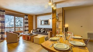 Un comedor con una mesa de madera dispuesta para cuatro personas, un sofá y una chimenea.