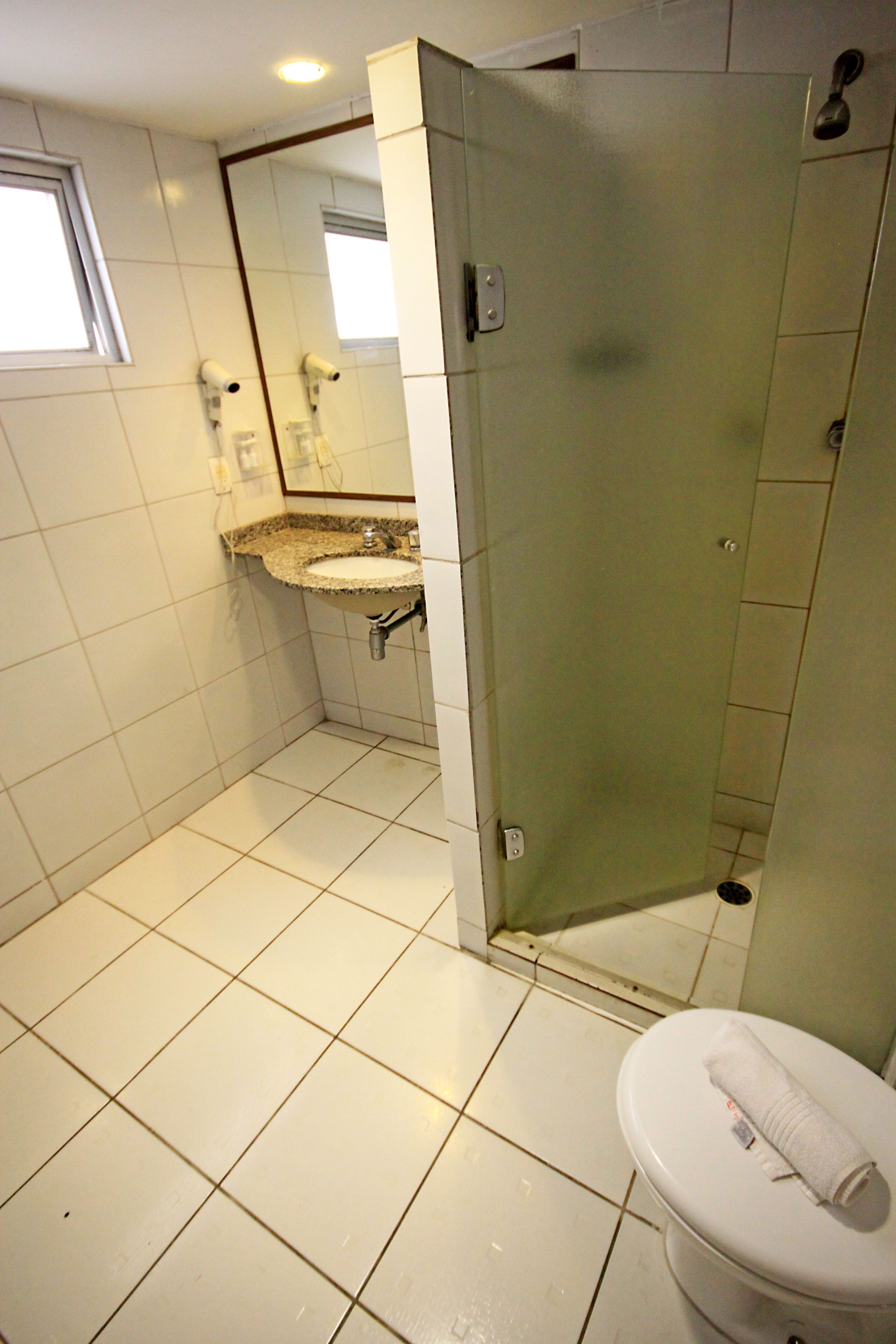A bathroom with a toilet, sink, and shower.