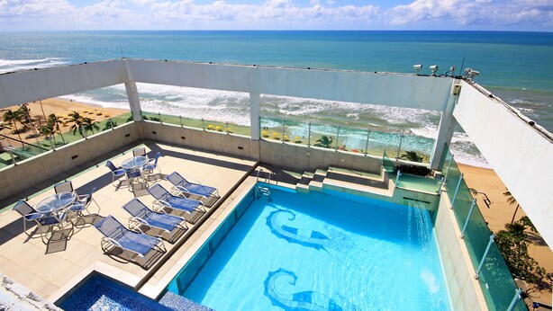 A rooftop pool with a view of the beach and ocean. - Jangadeiro Hotel e Convenções (Recife)