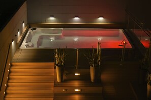 A modern spa area with a heated floor, a red heated tub, and potted plants. - Hampton by Hilton Valledupar (Valledupar)