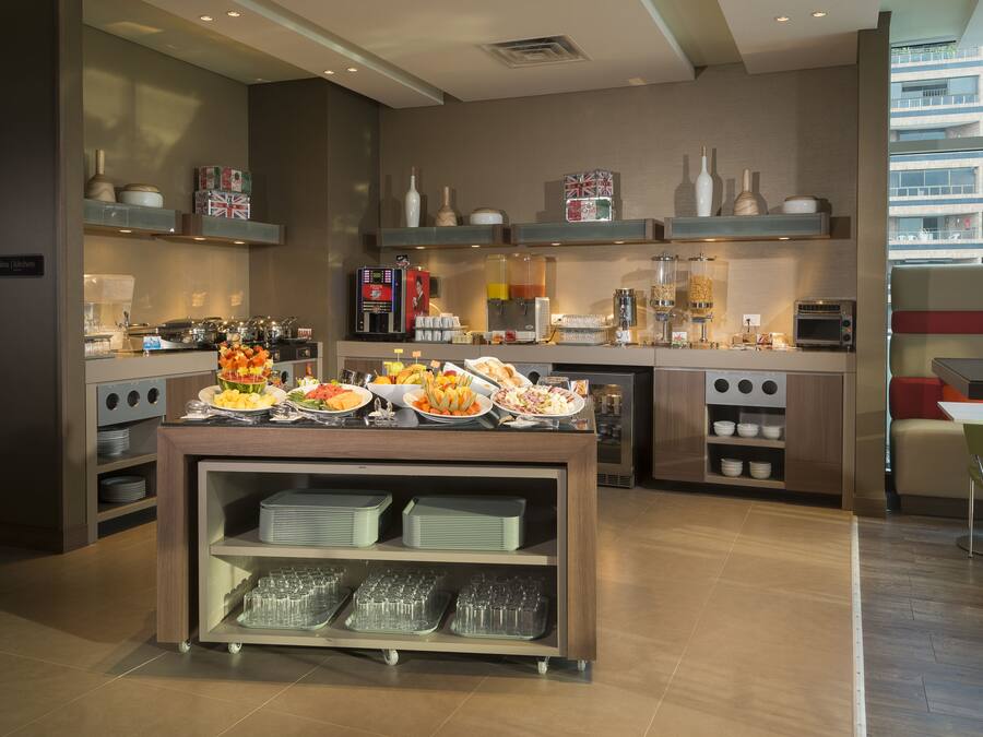 A modern kitchen with a buffet setup, including various food items and kitchen appliances.