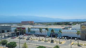 Zona comercial con estacionamiento, una estación de metro y un edificio con un letrero.