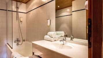 A bathroom with a bathtub, a sink, and a mirror.