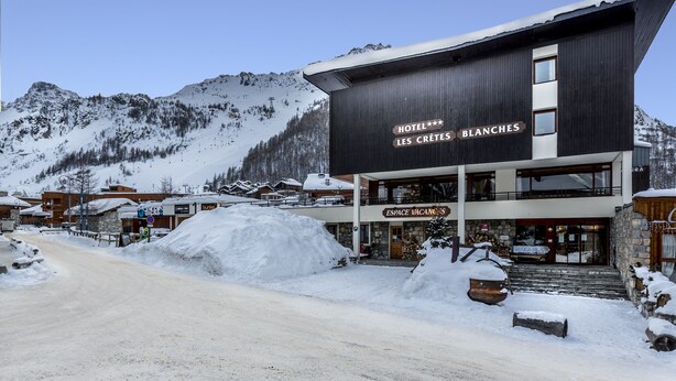 A hotel named "Hotel Les Cretes Blanches" with a modern design, a ski slope in the background, and a snow-covered environment. - Les Crêtes Blanches (Val-d'Isere)