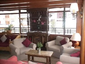 Cozy living room with armchairs, coffee table, fireplace, and floor lamps.