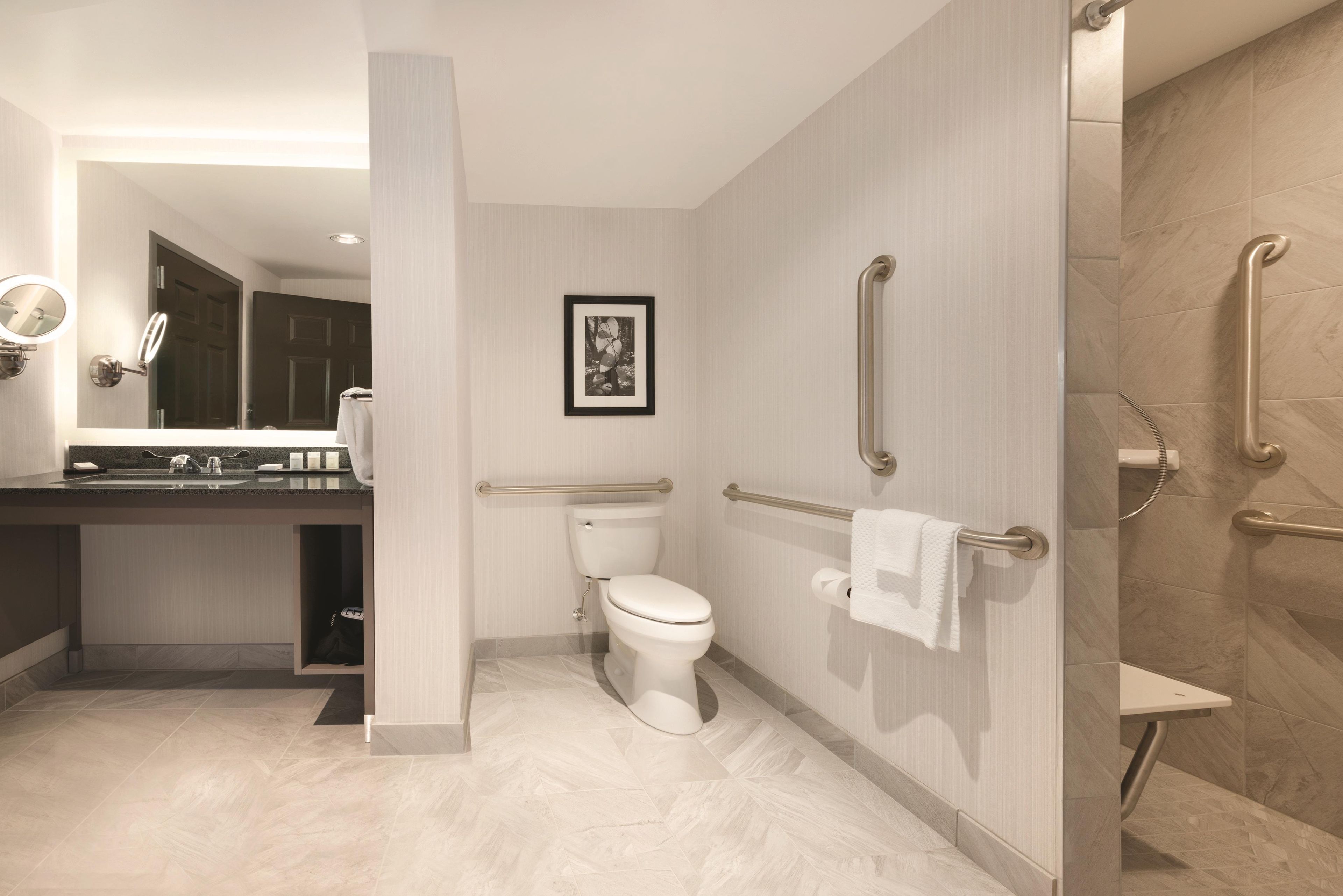 A modern bathroom with a toilet, sink, and shower.