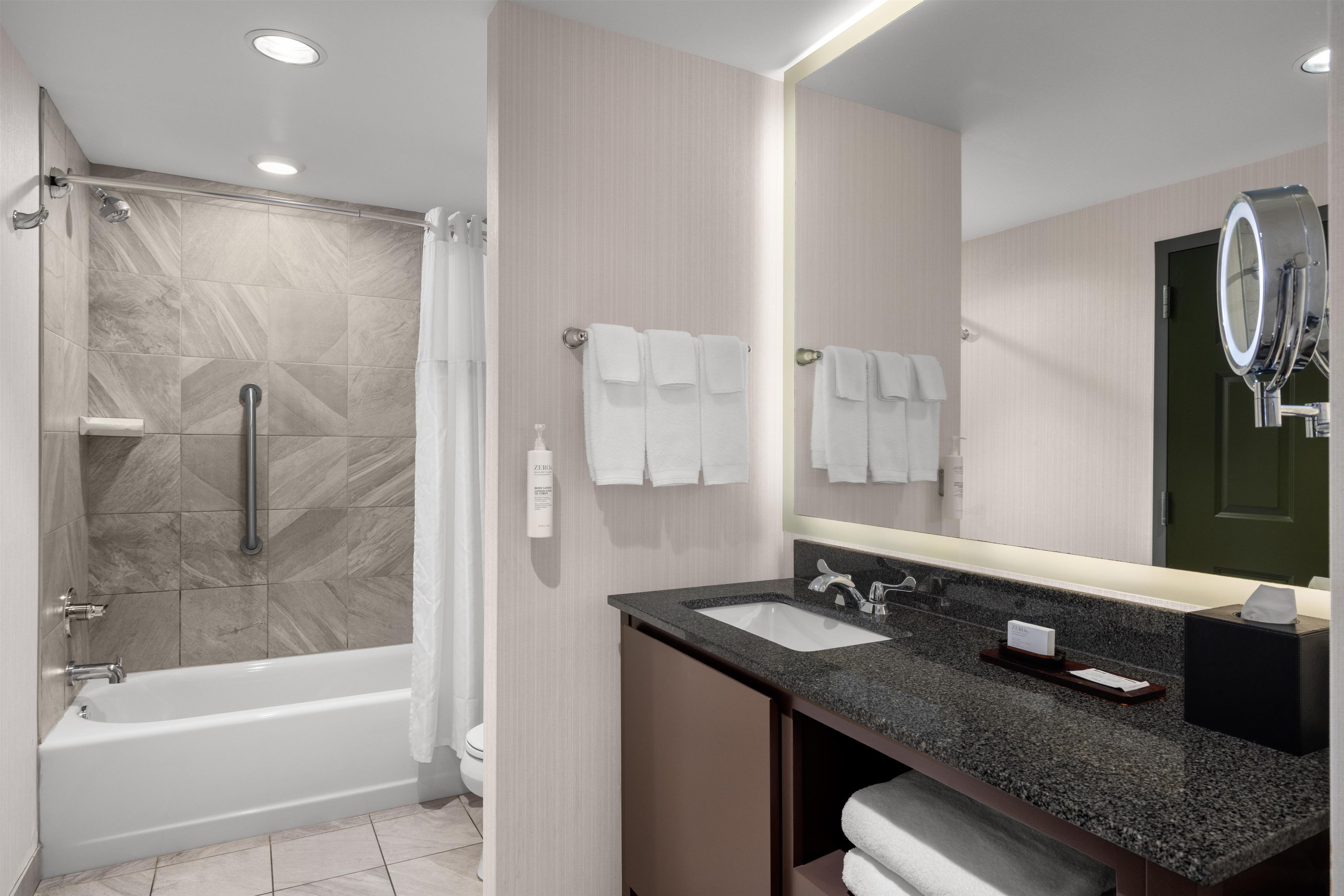A modern bathroom with a shower, a sink, and a toilet.