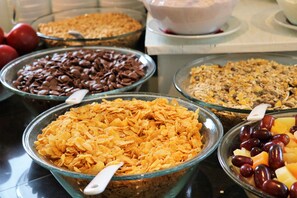 A buffet with various food options including cereal, chocolate chips, and fruits. - Hotel Excelsior (Dortmund)
